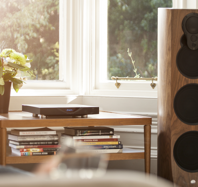 Linn Klimax DS on top of a wooden coffee table in front of a window.
