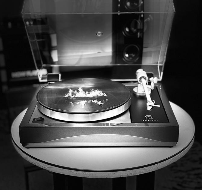 Linn Majik LP12 MC Turntable with custom green plinth with a 360 speaker in the background shot in black and white