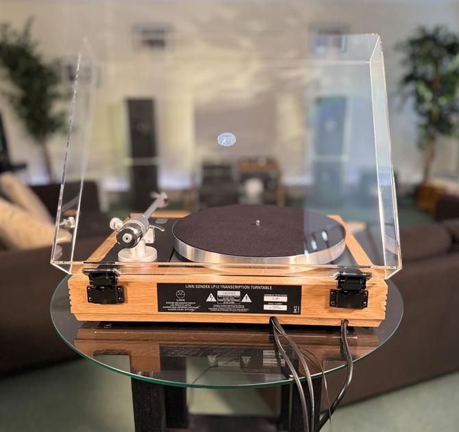 Linn Majik MM LP12 Fluted turntable in oak in the ripcaster showroom with sofas and speakers in the background along with other HiFi equipment