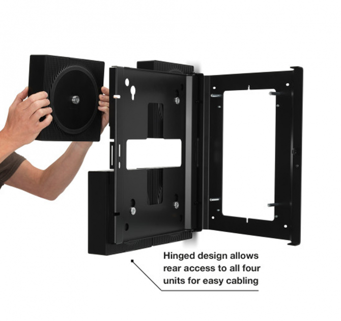 Flexson Wall Mount x4 Amp Black x1 with hands placing the last Sonos Amp in place.  Has the words "Hinged design allows rear access to all four units for easy cabling".