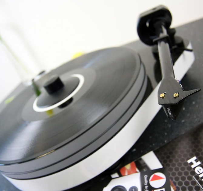 Project RPM 5 Carbon - Turntable in white pictured at an angle with a product catalogue.