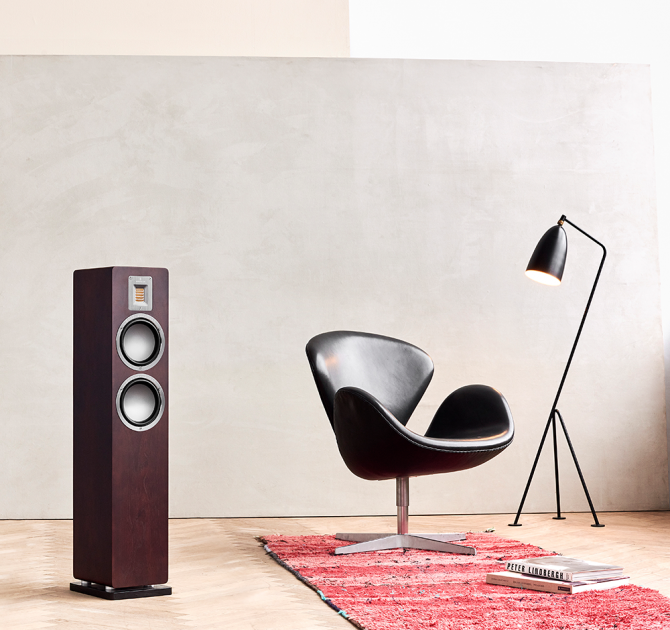 Audiovector QR3 in dark walnut with a chair and a floor lamp beside it.