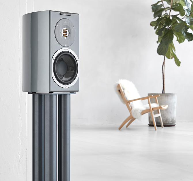 Audiovector R1 Signature in custom grey with a chair and large houseplant in the background