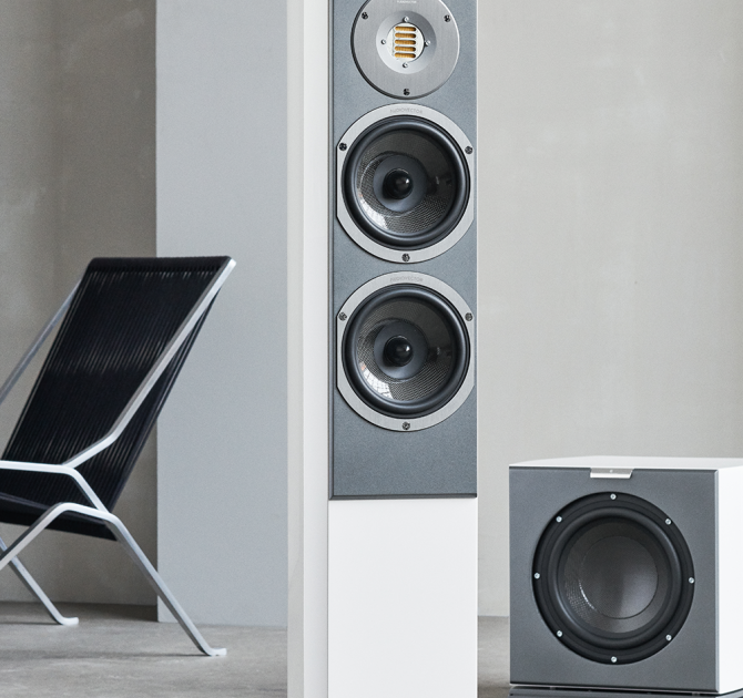 Audiovector R3 Arreté in white with a sub one side and a chair the other