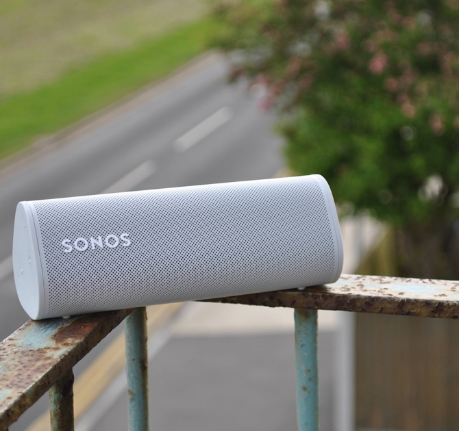 SONOS Roam in white on a rusty balcony overlooking a road