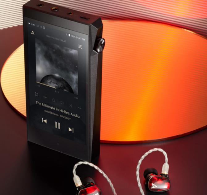 Astell & Kern A&Ultima SP2000T Portable Music Player standing on a table with earphone beside it.