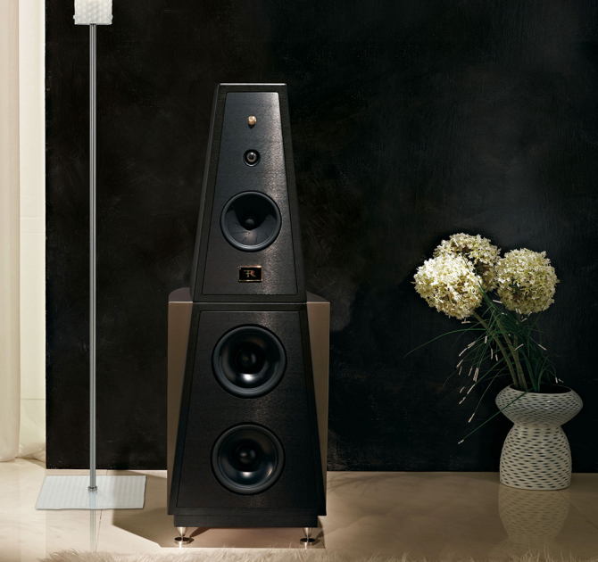 Rosso Fiorentino Siena 2 Loudspeaker in a living area with a vase of flowers on the floor to the right of the image.