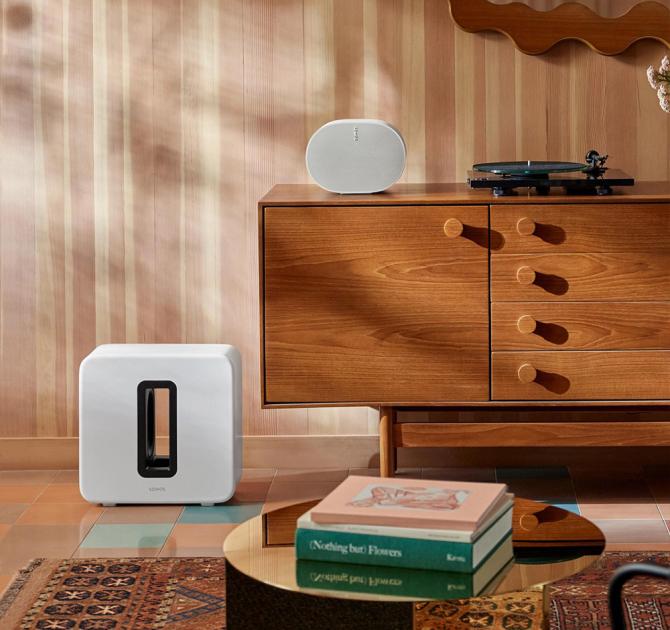 Sonos Sub Gen 4 in white on the floor beside a wooden side-board