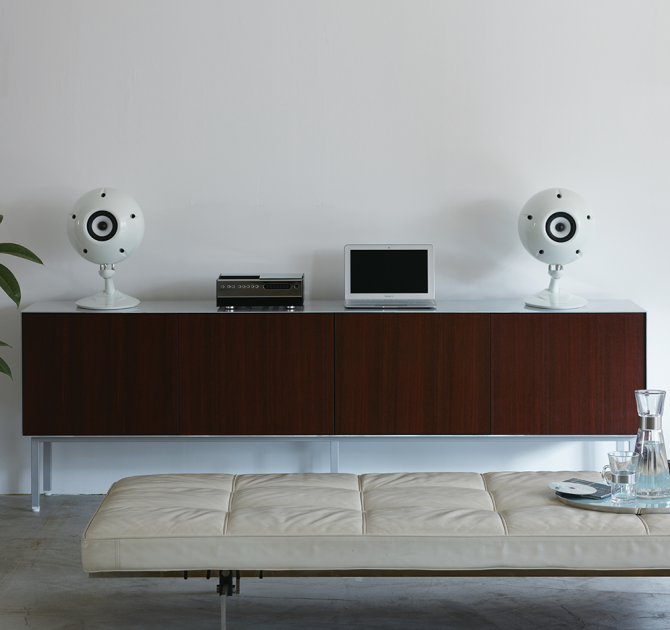 Eclipse TD510MK2 Speaker - a pair in white on top of a unit with a laptop and a music player.