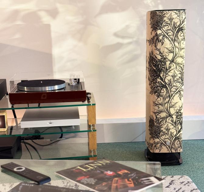 One of the ripcaster Linn 530 Thistle speakers with an LP12 beside it and an album and a remote control in the foreground