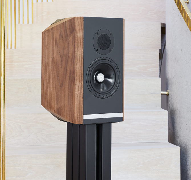 A single Titan 505 speaker with its grill off on a stand at the foot of a staircase.