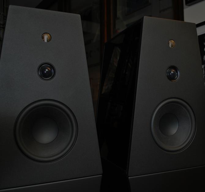A pair of Rosso Fiorentino Volterra speakers in black.  A close-up of the top half of the speakers.