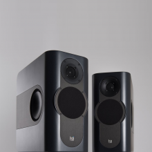 A pair of Kii Three Loudspeakers in a dark grey matt colour