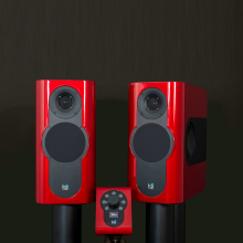 A pair of Kii Three Loudspeakers in gloss red with the Kii controller also in gloss red.