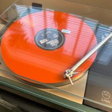 An orange record on the Majik LP12 turntable.  The lid is shut and the needle is on the first song.  The album is "The Shocking Miss Emerald"