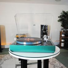 Linn Majik LP12 MC Turntable with a custom green plinth.  There are other pieces of HiFi kit in the background.
