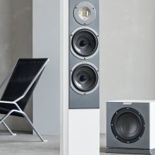 Audiovector R3 Arreté in white with a sub one side and a chair the other
