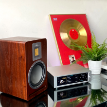 Rose RS-201E Streamer, DAC and amplifier showing 'Yello' playing, and Audiovector speaker beside it and a mug.