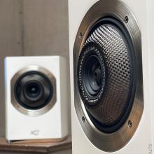A pair of Cabasse Rialto Loudspeakers in white.  One up close and the other further away.
