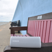 SONOS Roam in white on the end of a bench by the sea front
