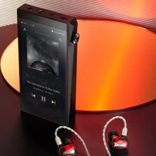 Astell & Kern A&Ultima SP2000T Portable Music Player standing on a table with earphone beside it.