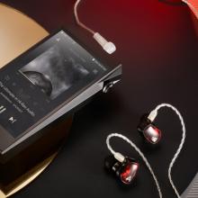 Astell & Kern A&Ultima SP2000T Portable Music Player laying on a table with earphone connected