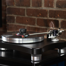 VPI Scout 21 Turntable in action with a brick wall behind.