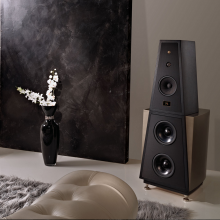 Rosso Fiorentino Siena Loudspeaker in a living area with a vase of flowers to the left of the image