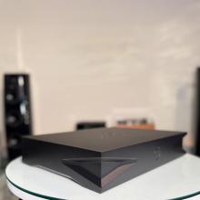 Kudos Sigao drive in black on a white circular table in the ripcaster showroom.  There's a few other pieces of HiFi in the background including the Linn 360 speakers