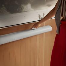 SONOS Arc Ultra Smart Soundbar in white with a woman touching the top of it